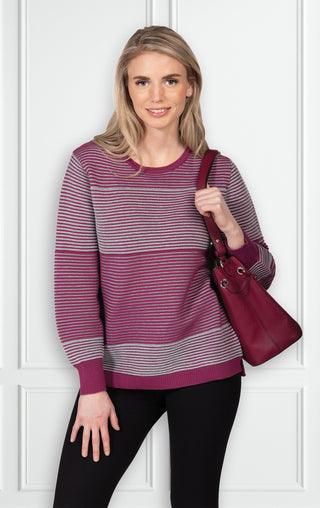Woman wearing striped two-tone sweater with crew neckline and long sleeves wine/gray color