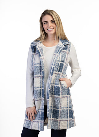 Model wearing a collared plaid longline vest jacket layered over a long-sleeve top